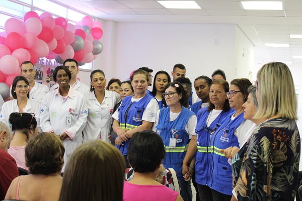 #PraCegoVer: Agentes comunitários da Saúde, na celebração do Dia do Idoso. Todos estão em pé e sorrindo de coletes azul.